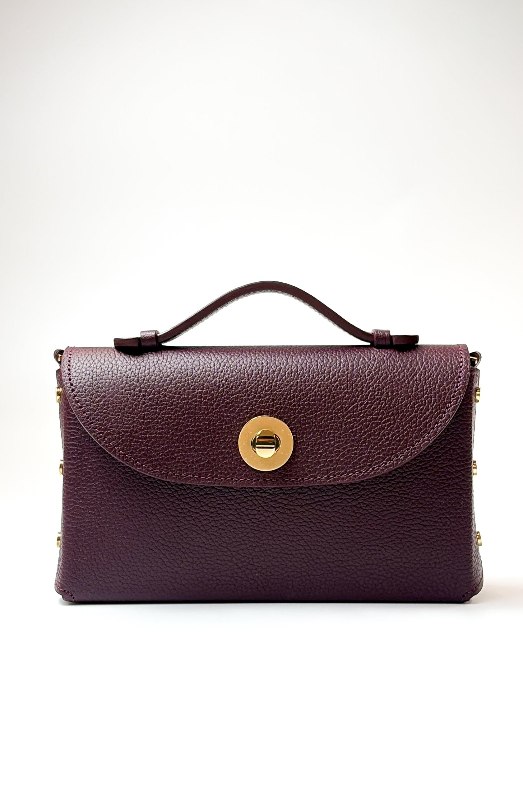 Burgundy leather handbag with a gold clasp on a white background