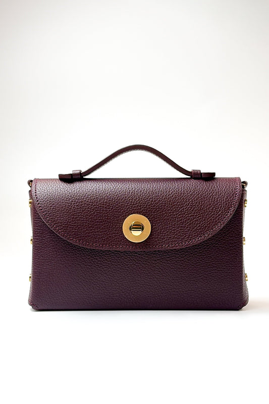 Burgundy leather handbag with a gold clasp on a white background