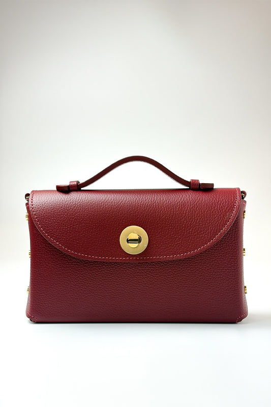 Red handbag with a gold clasp on a white background