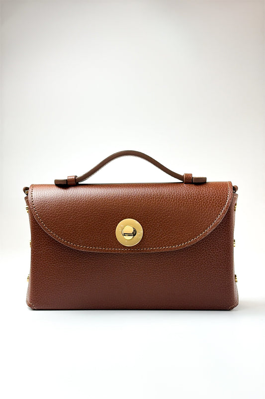 Brown leather handbag with a gold clasp on a white background