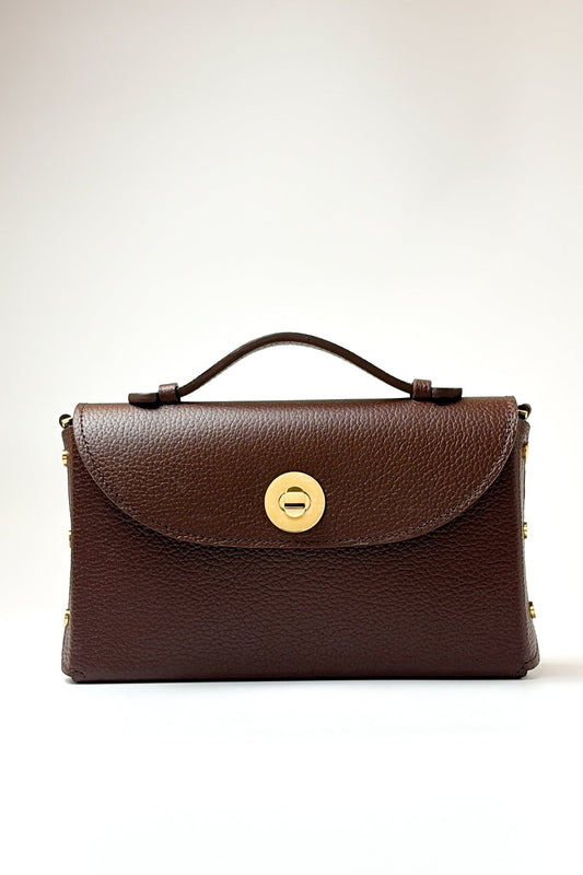 Brown leather handbag with a gold clasp on a light beige background