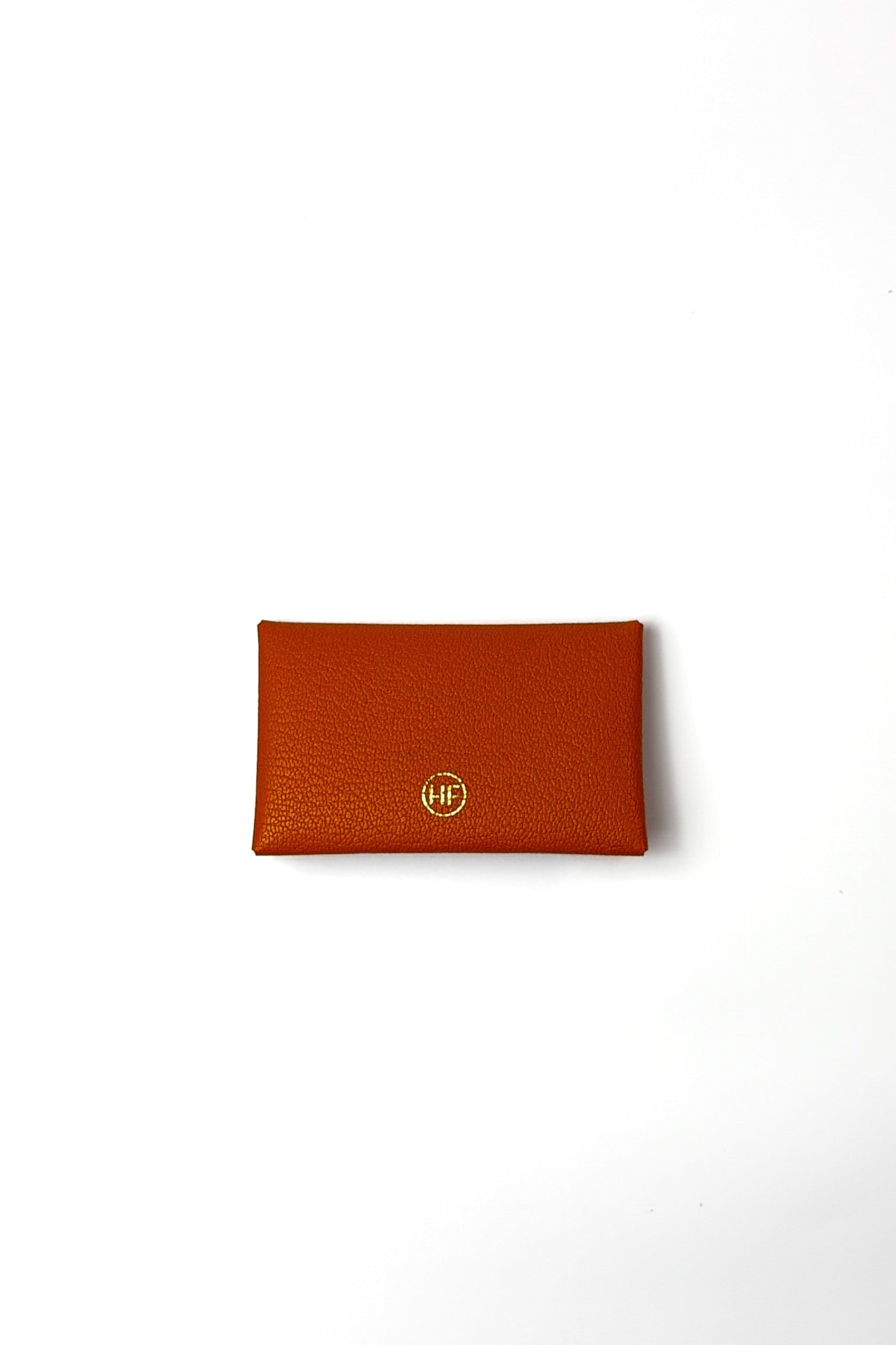orange leather wallet with a gold logo on a white background