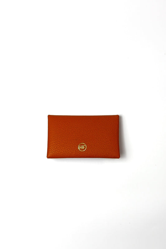 orange leather wallet with a gold logo on a white background